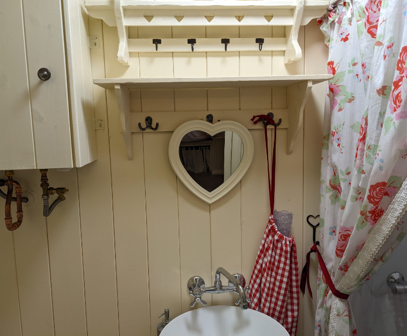 picture of heart shaped mirror above hand basin